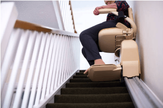 A person sitting on a stair lift going up stairs